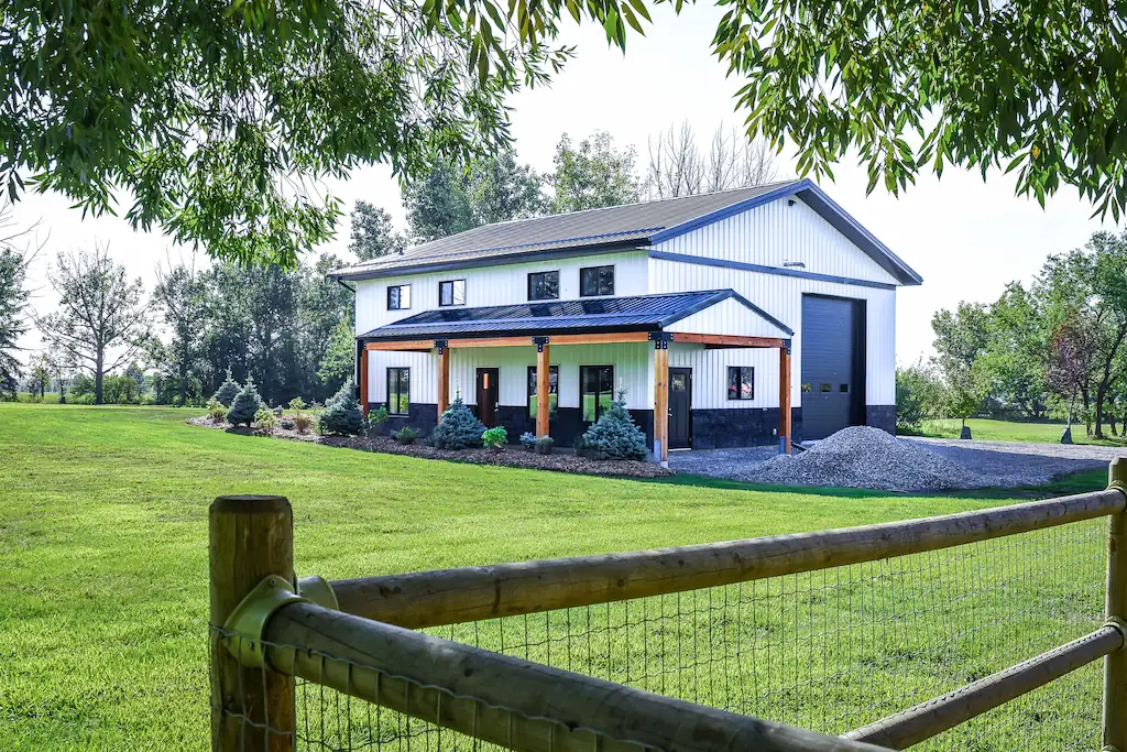 Trees and fence frame a 40' x 40' shop with living quarters on an acreage