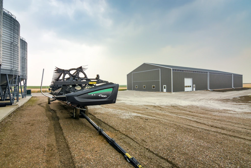 Large equipment cold storage building with grain bins in the foreground