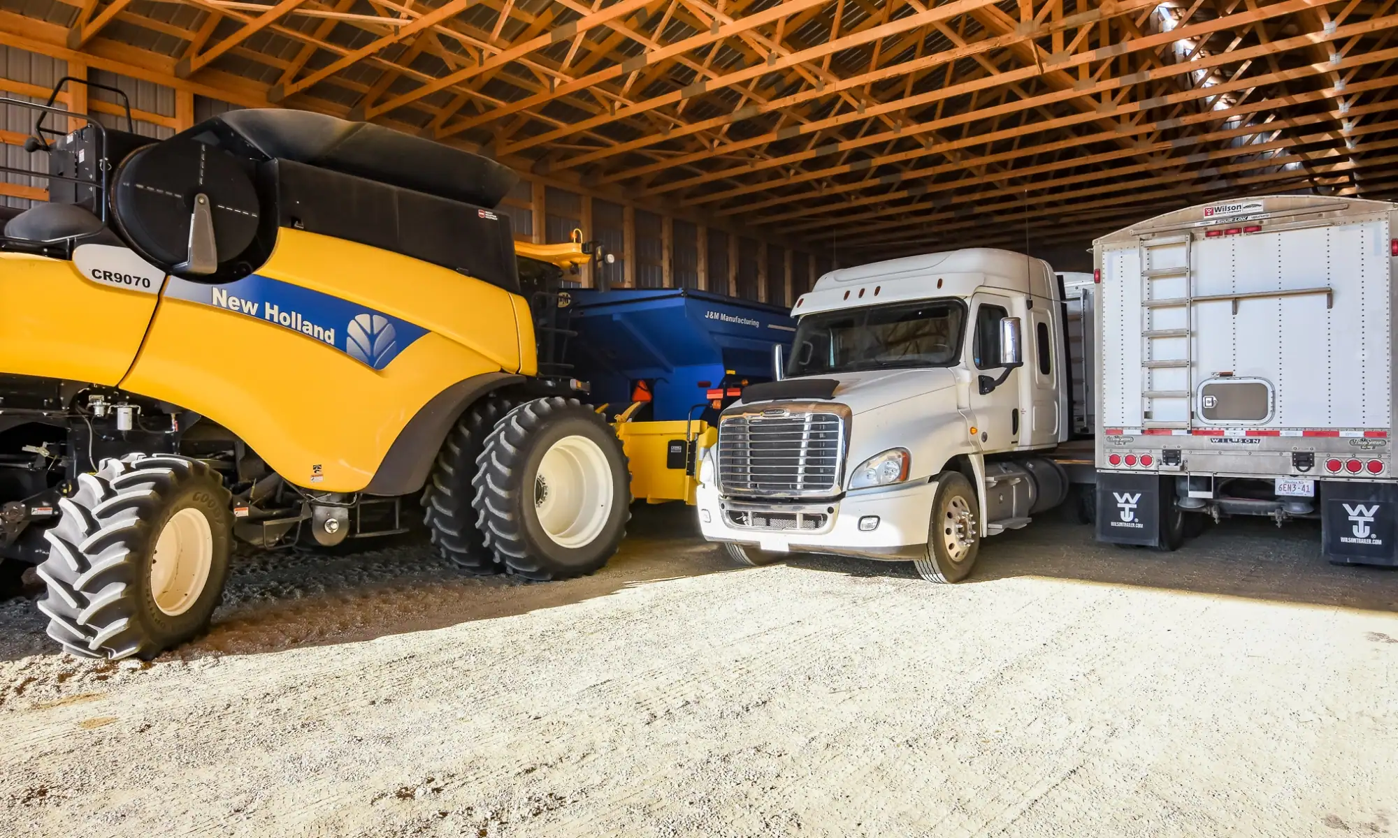 Interior of a cold storage farm building storing trucks, tractors, and agricultural equipment safe from harsh weather.