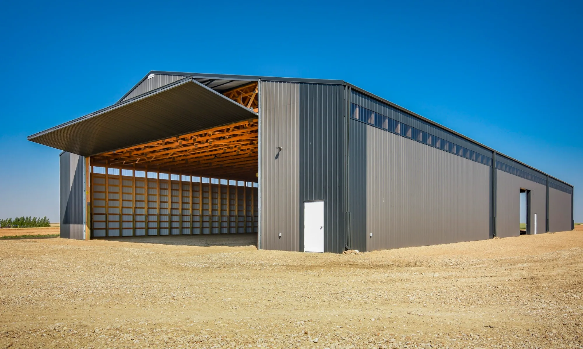 Large farm building with spacious clearance to accommodate agricultural equipment built for cold storage. A bi-fold door provides easy access for combines, tractors, trucks, and trailers.