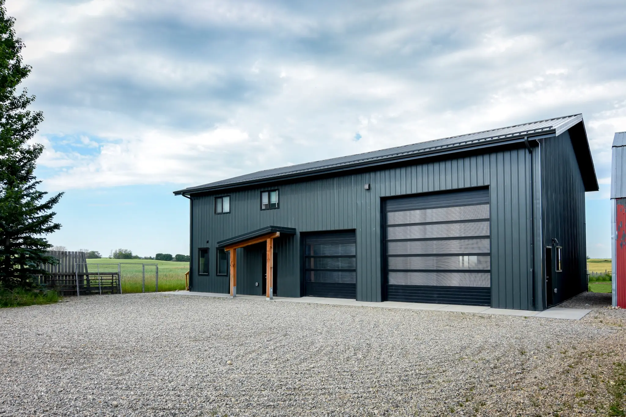 A dark grey multi-use post frame building with living quarters exterior.