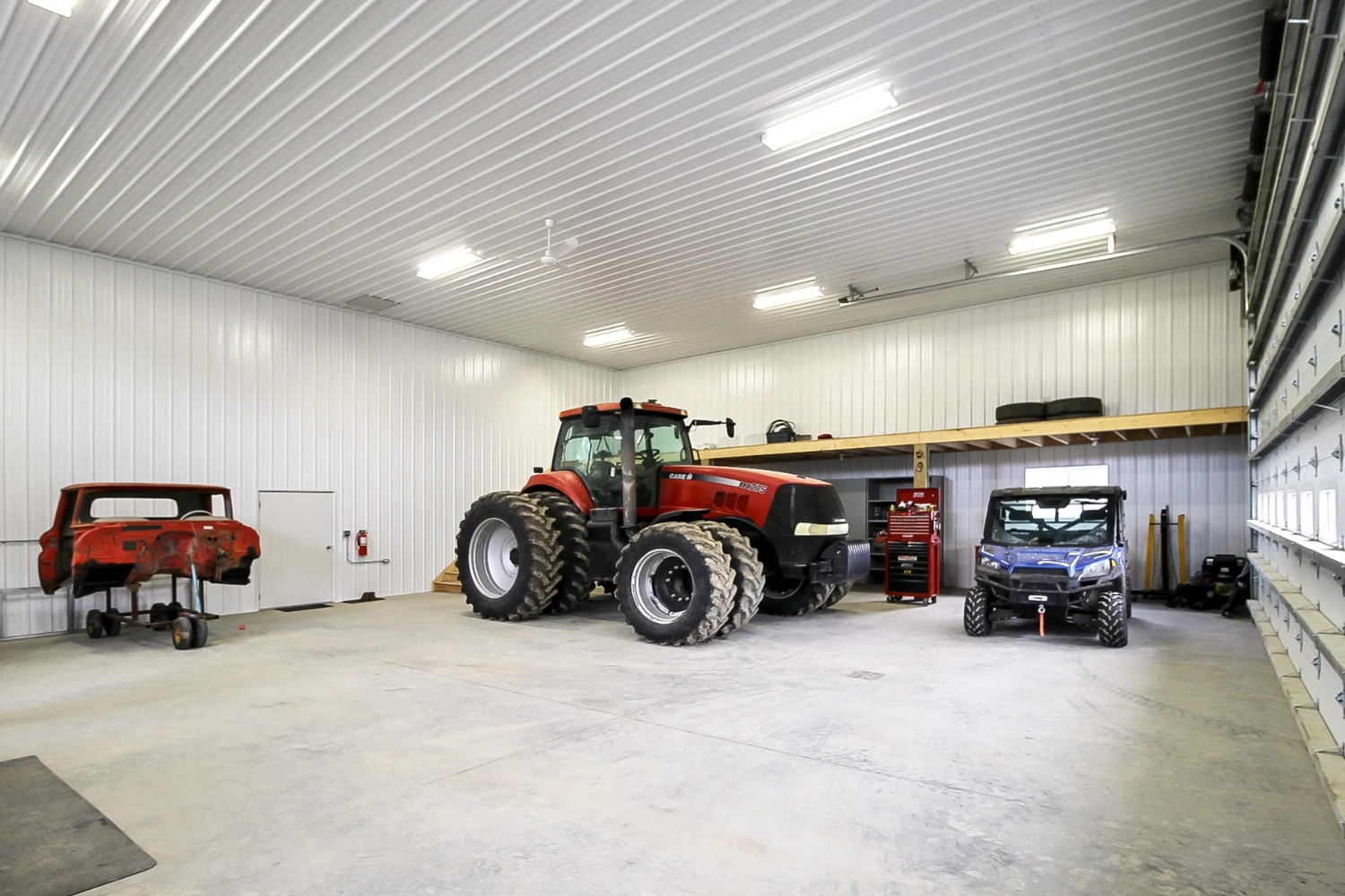 The interior of a heated shop building with equipment stored inside has a mezzanine for smart storage.