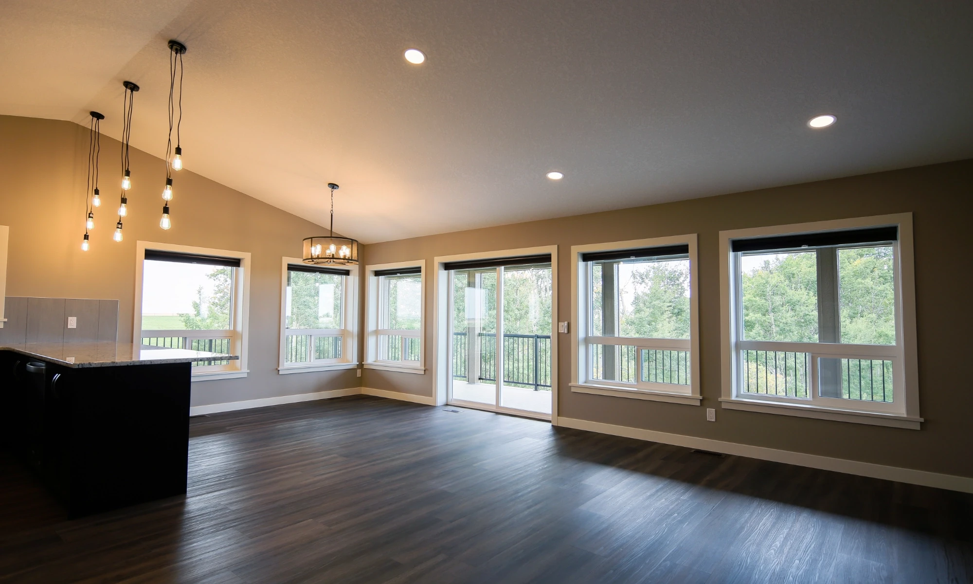 Open-concept interior of a modern barndominium with large windows that provide plenty of natural light.