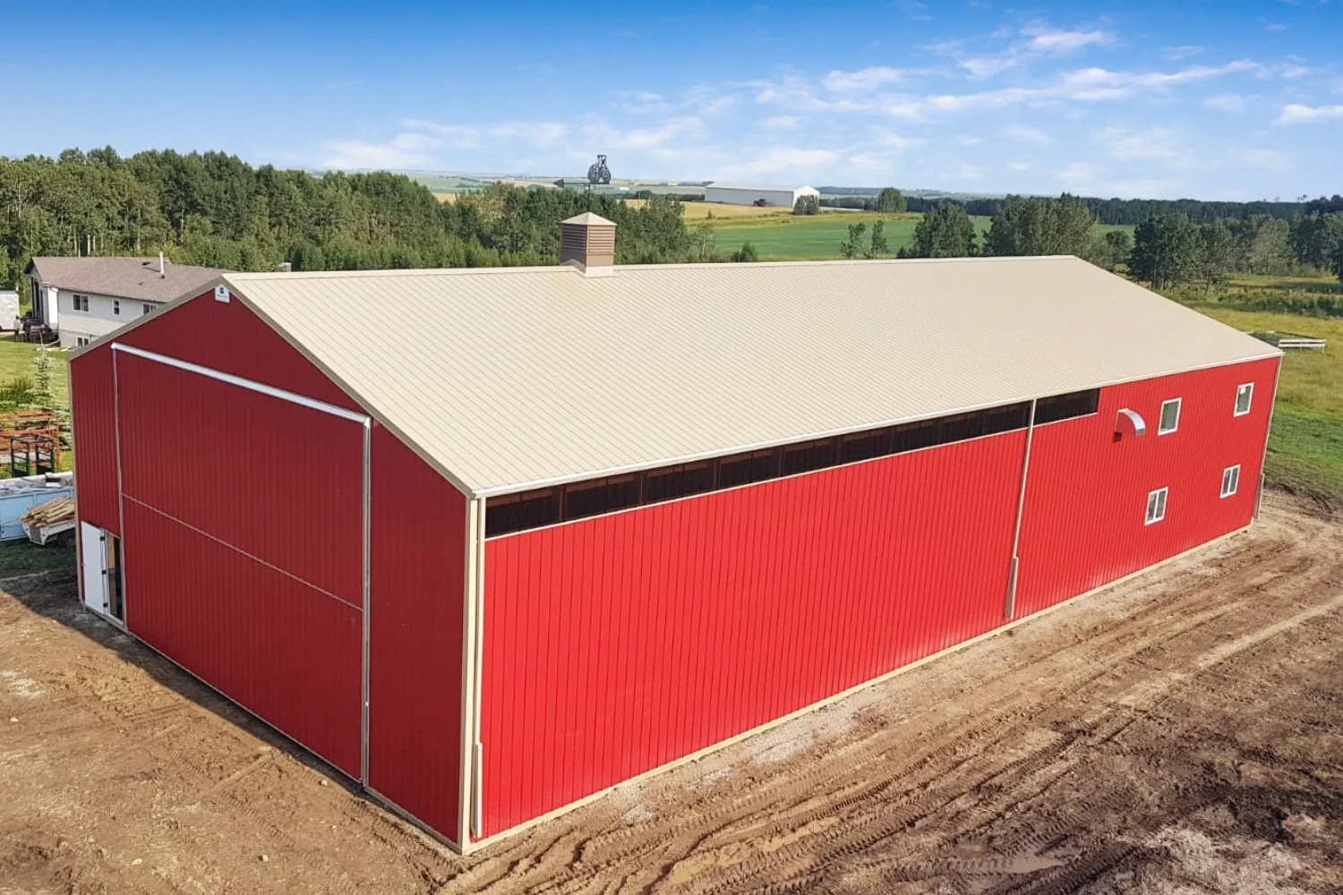 The interior of a red shop building is separate by a demising wall. In this photo, the exterior shows the demising wall where the windows stop.