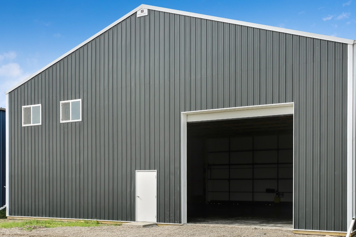 An additional overhead door on the back of an airplane hangar supports the movement of tools and other items.