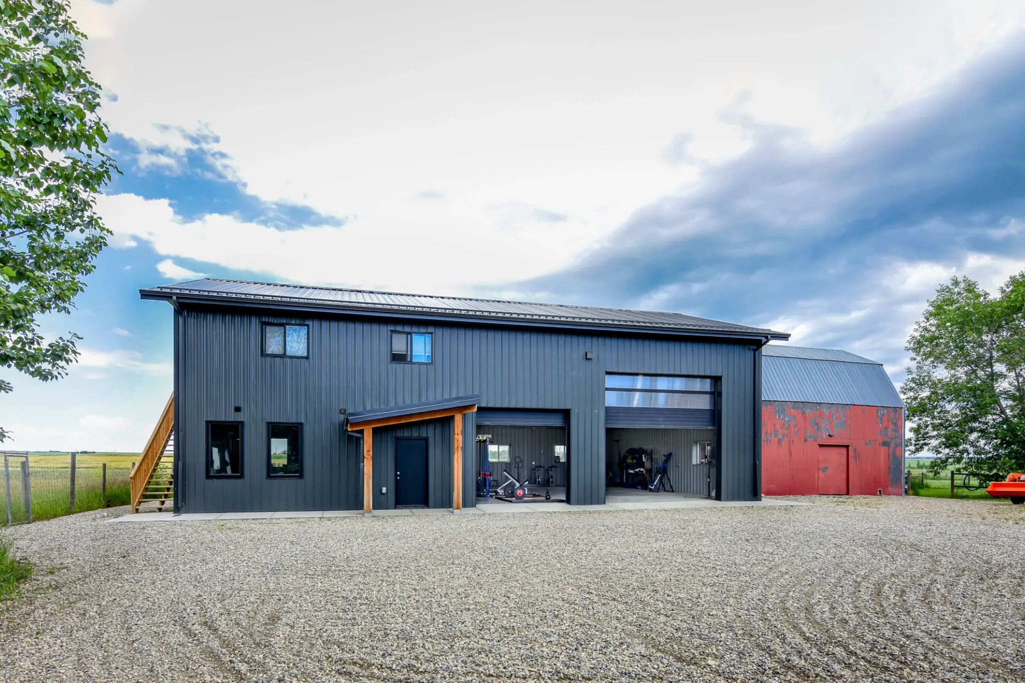 The overhead doors on this post frame building with living quarters are partially open to increase airflow into the gym.