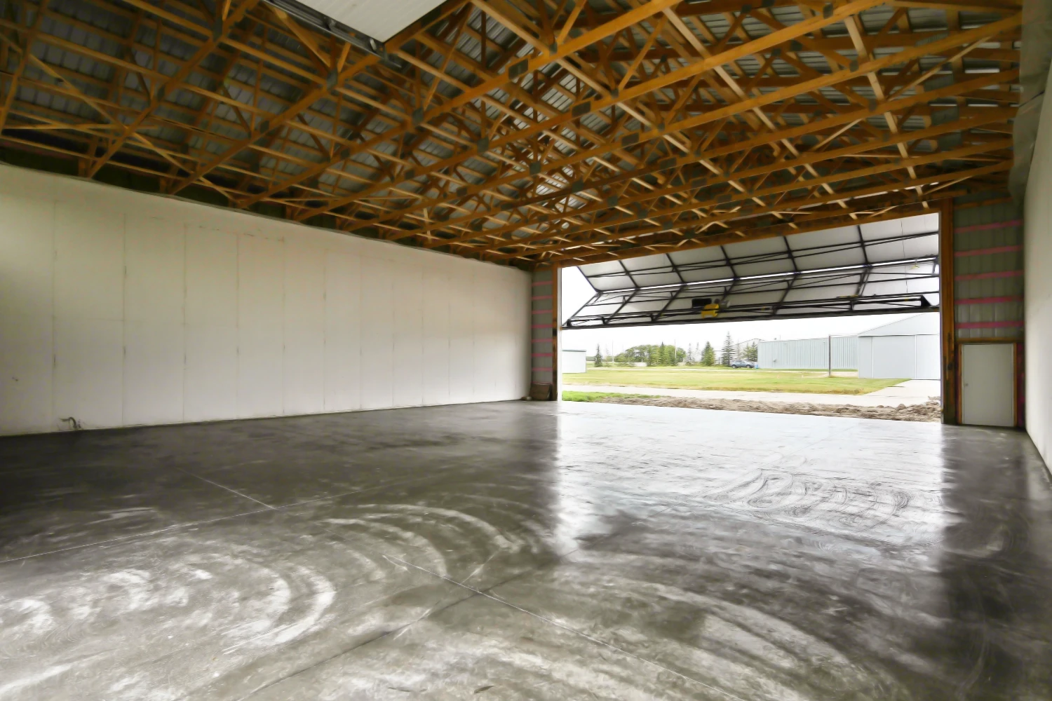 The interior of a post frame aircraft hangar features a concrete floor to easily move planes around.