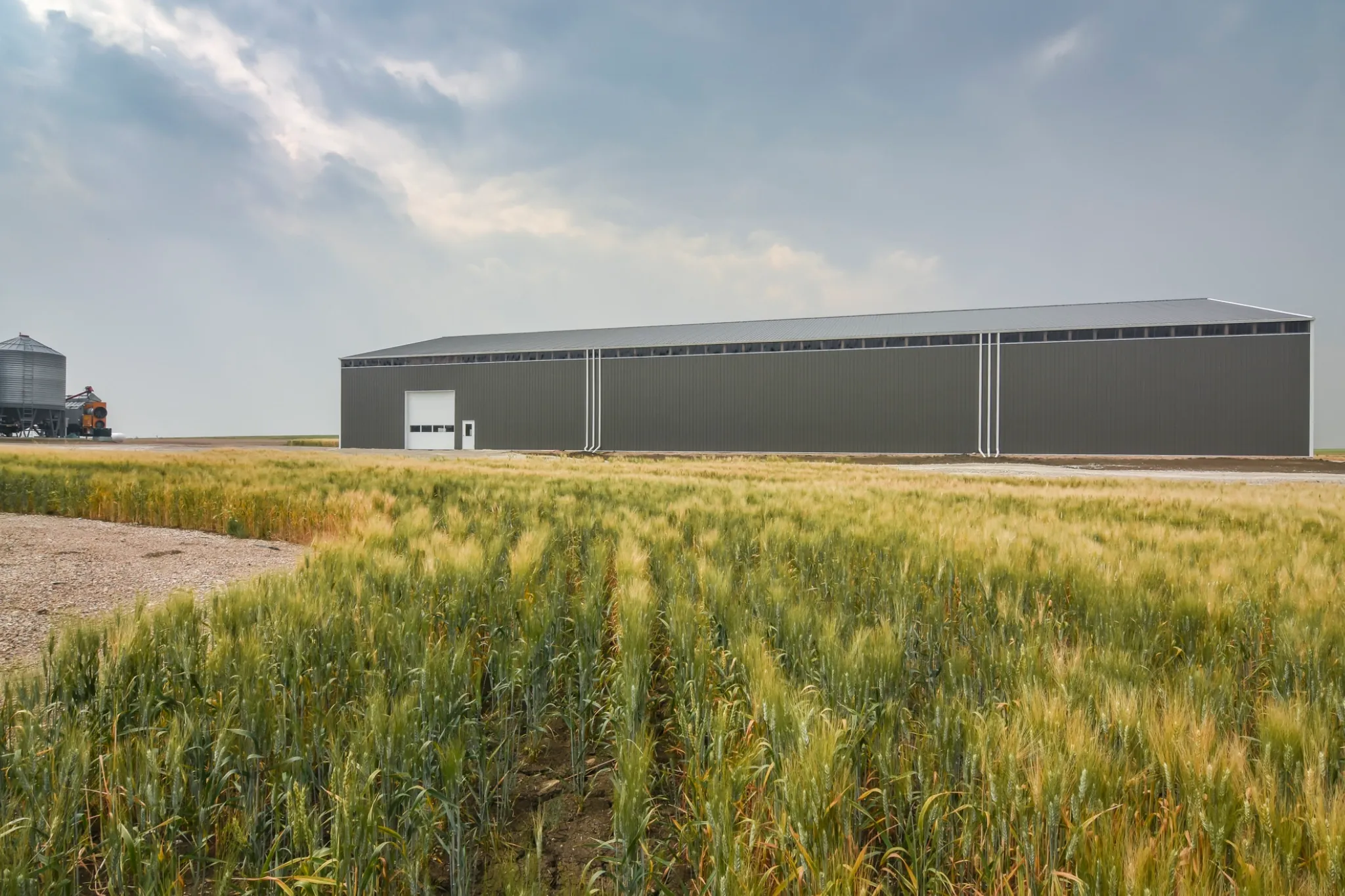 The side of a post frame building shows the scale and ability to create space for cold storage for farm equipment.