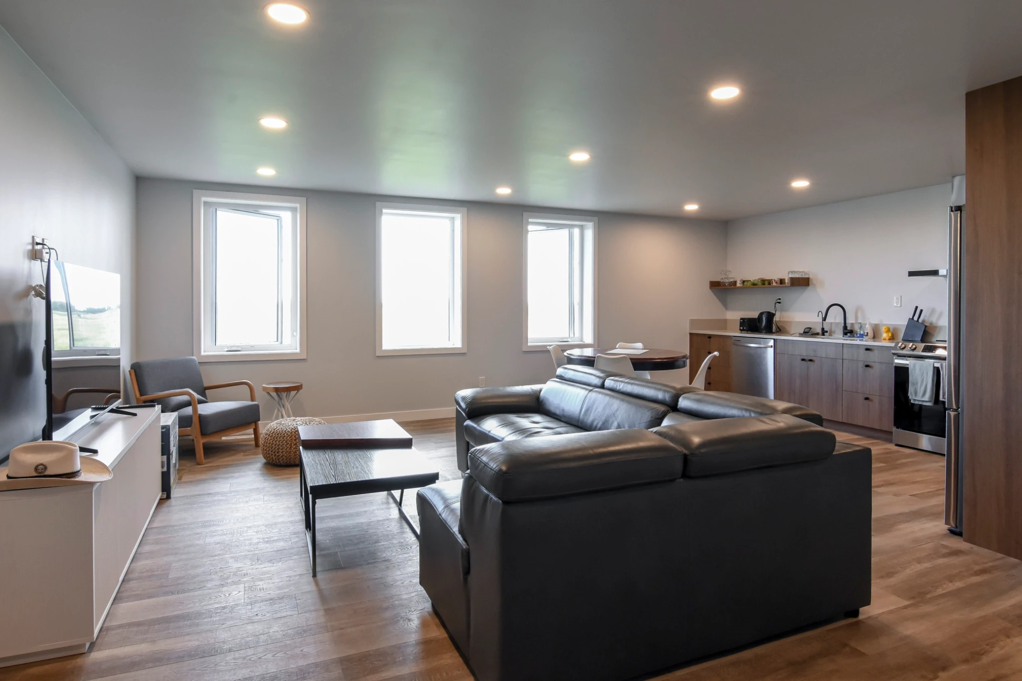 Three windows illuminate the interior of a post frame building with living quarters for a comfortable space.