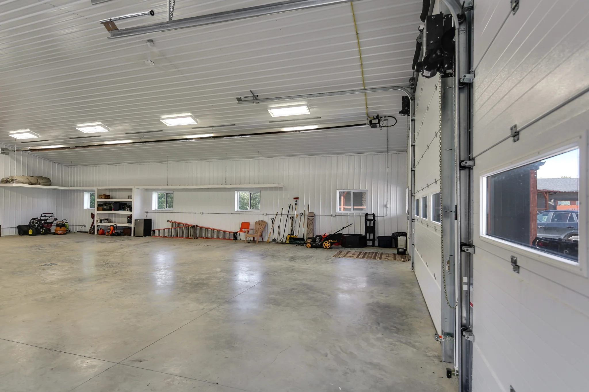 Windows and window panes inside the overhead doors on a acreage shop building with monitor roof creates a bright interior.