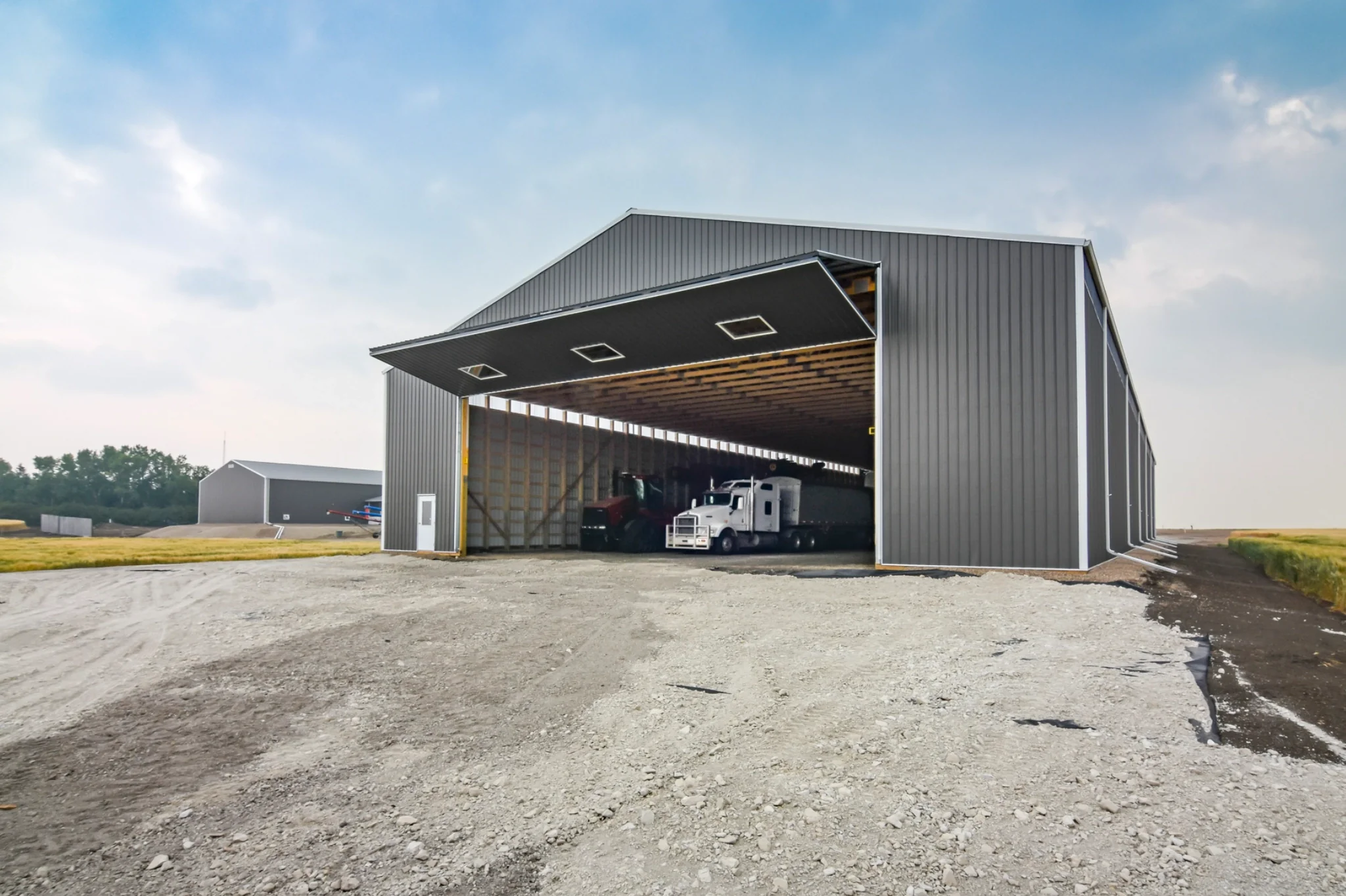 The interior of cold storage for farm equipment is revealed when a massive bi-fold door is open.