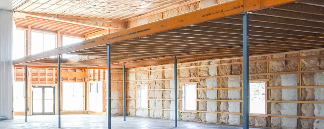 Interior of a post frame structure showing the kay traits that make them energy efficient. It has plenty of insulation and windows for light.