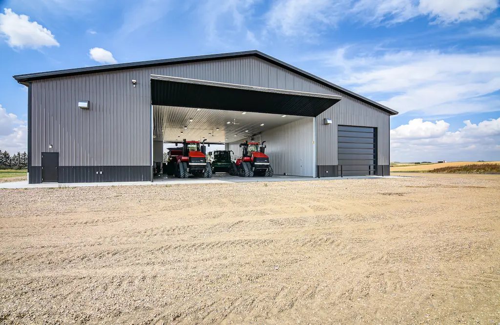 Farm equipment sits inside an insulated agricultural shop