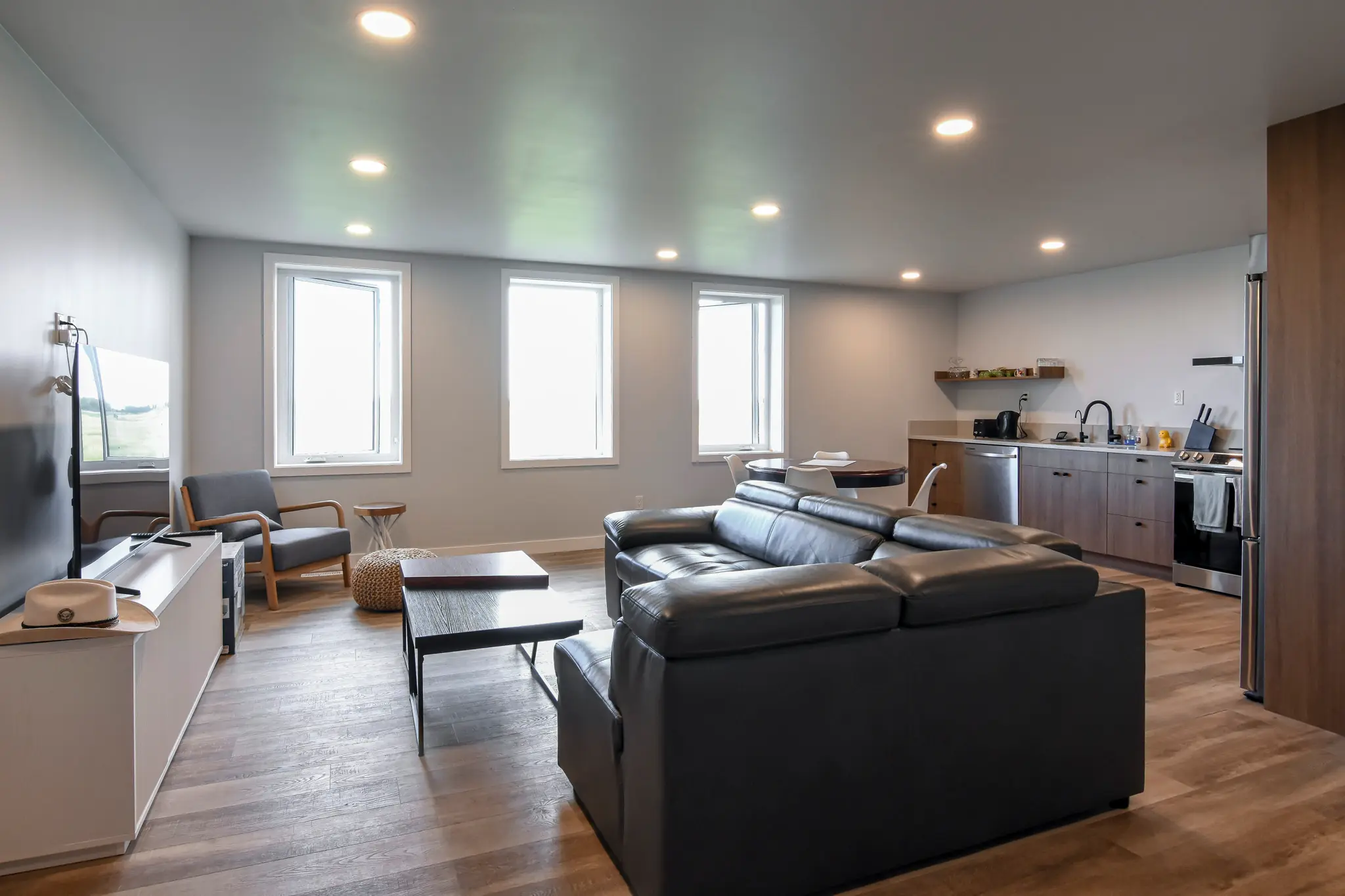 Three windows letting light into the guest suite in a post frame shop