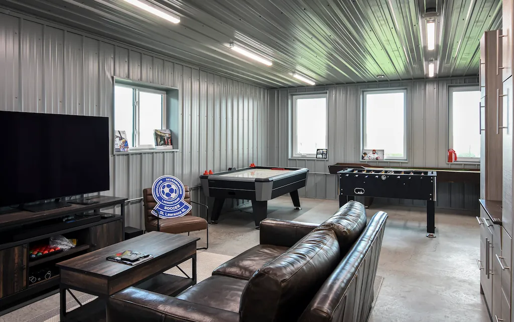The lounge area inside a 40' x 60' post frame shop with a couch, tv, and games