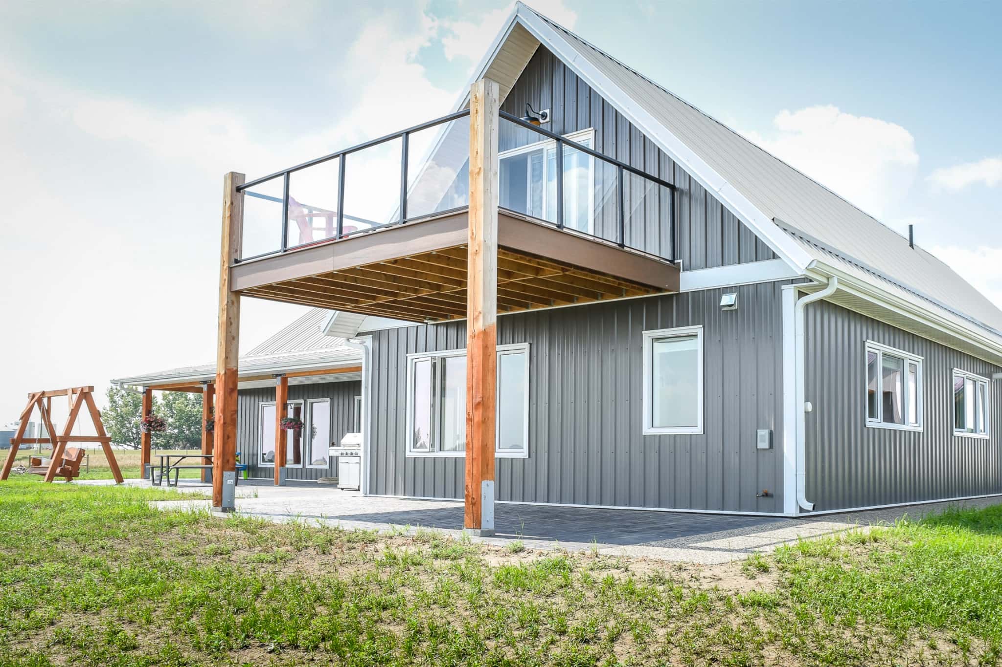 A second floor deck is attached to the loft of a post frame home.
