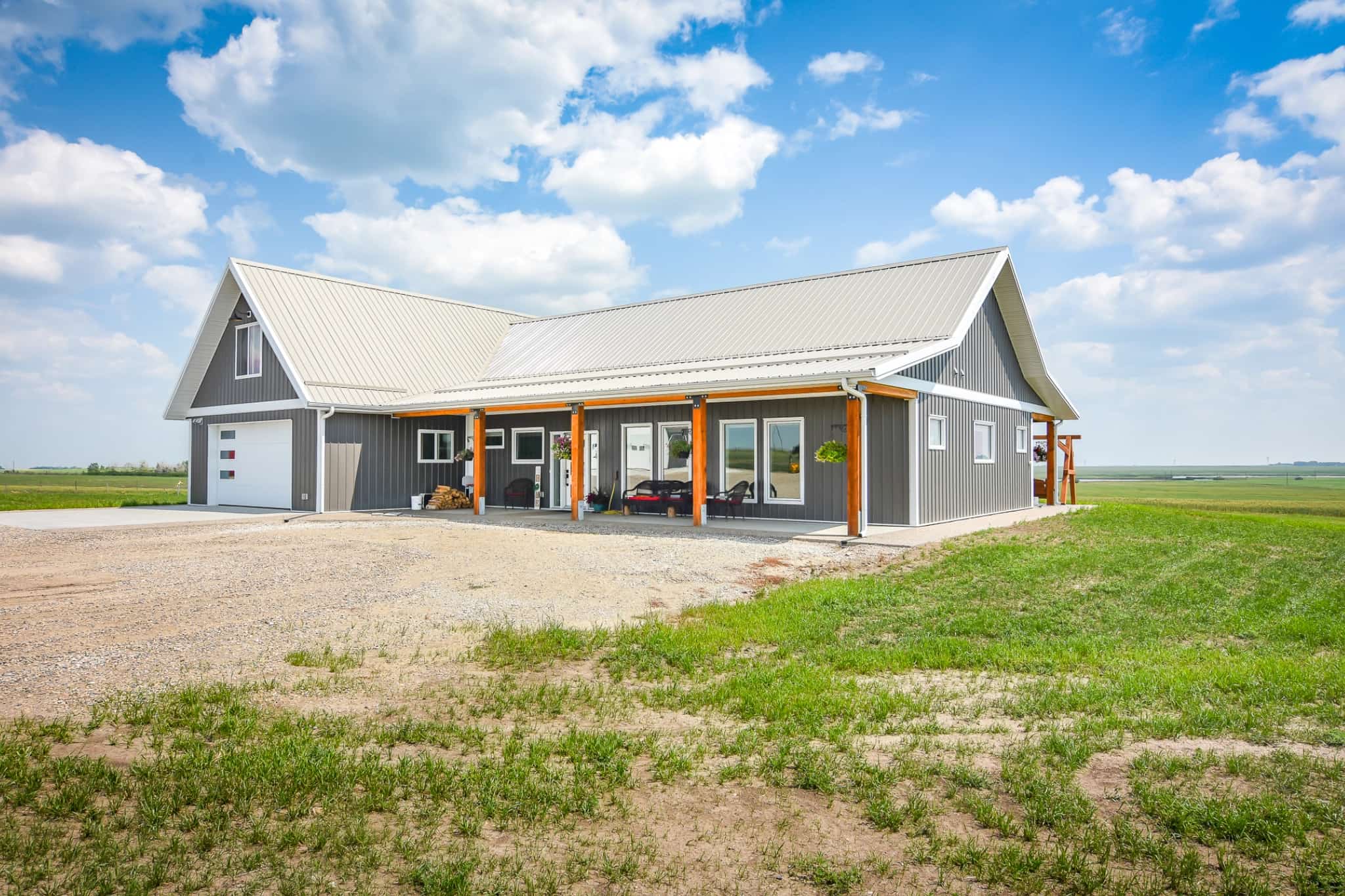 A post frame home with an attached garage on a rural property.