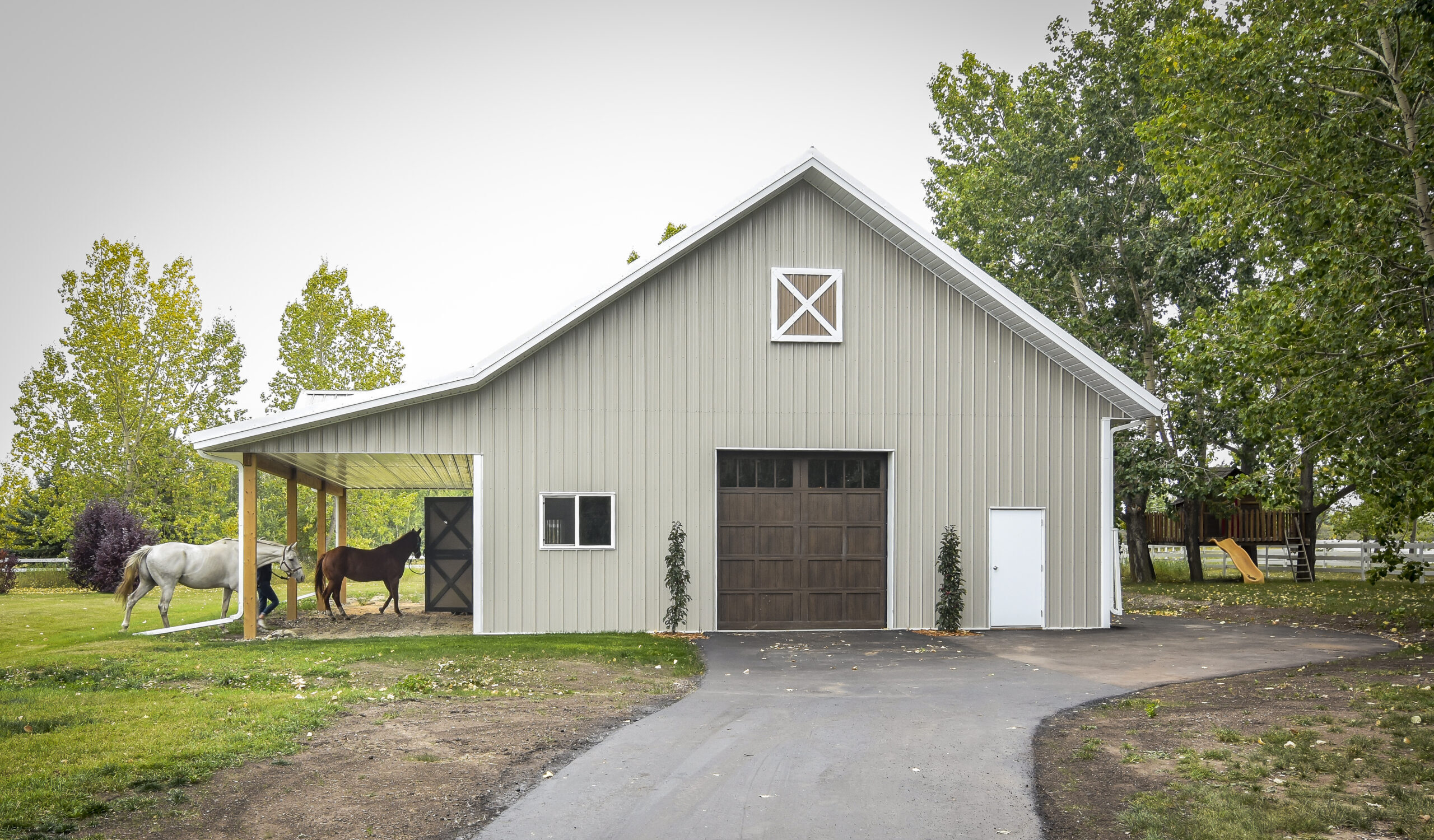 The exterior of a classic post frame barn. The horse barn features functional options for easy use and horse safety.