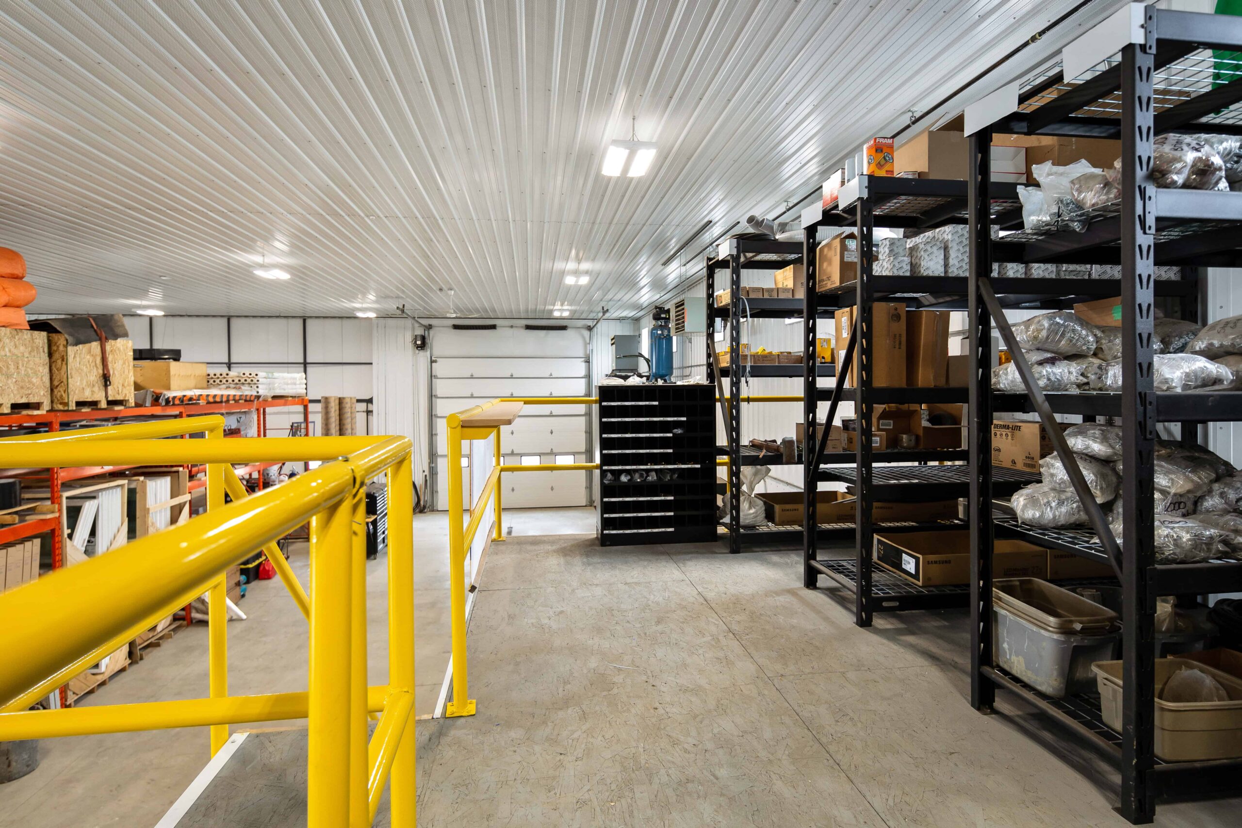 A view of a large, clear-span commercial warehouse from the upper mezzanine space