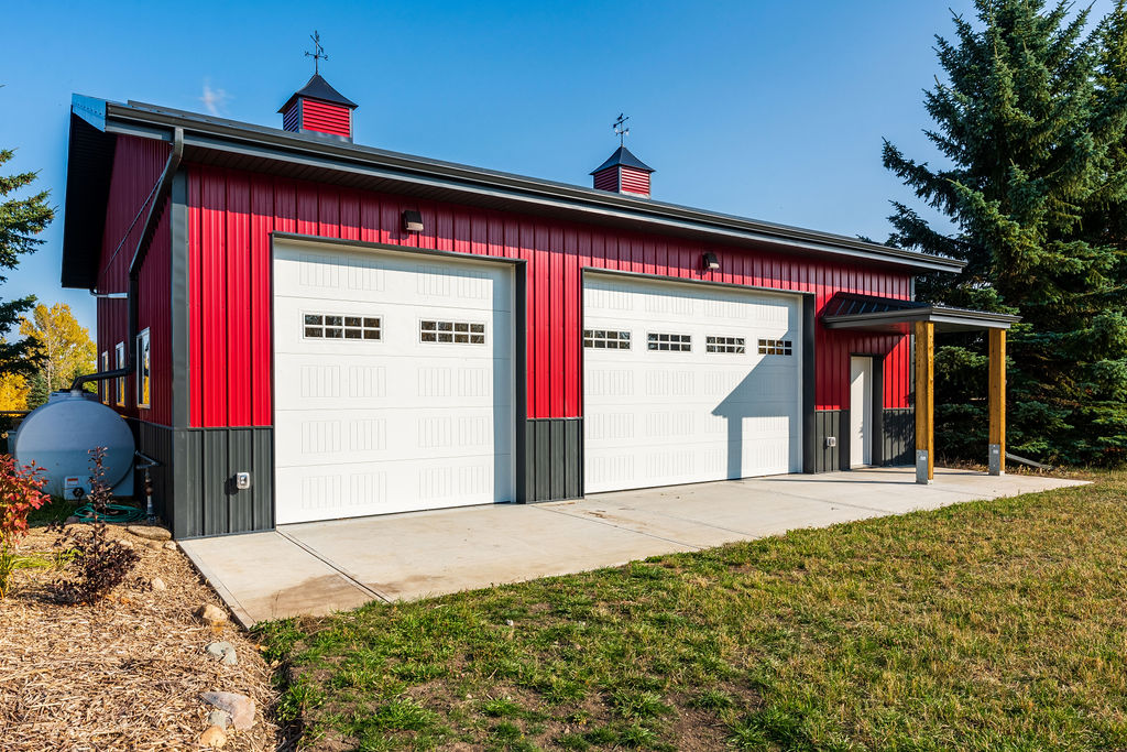 A custom acreage outbuilding that captures attention with premium features like wainscoting, cupolas, and window shutters