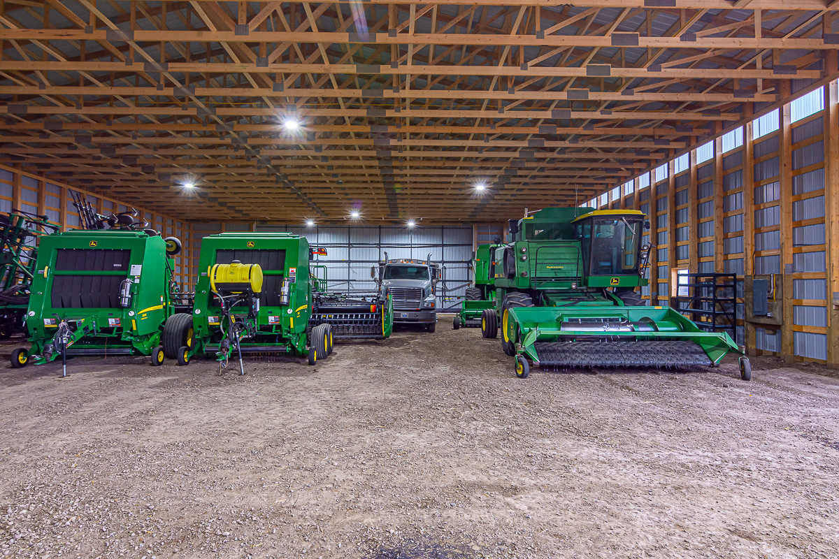 A collection of tractors and combines stored protected indoors for the winter