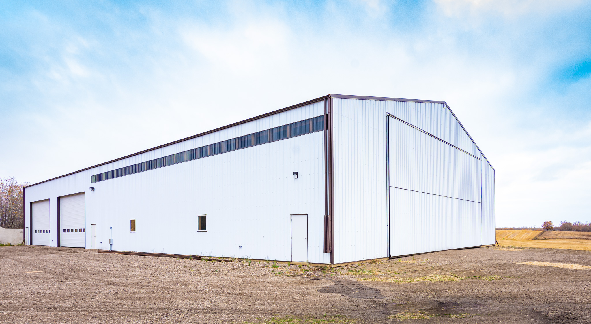 The exterior of a basic farm building intended for cold storage of machines and tractors.