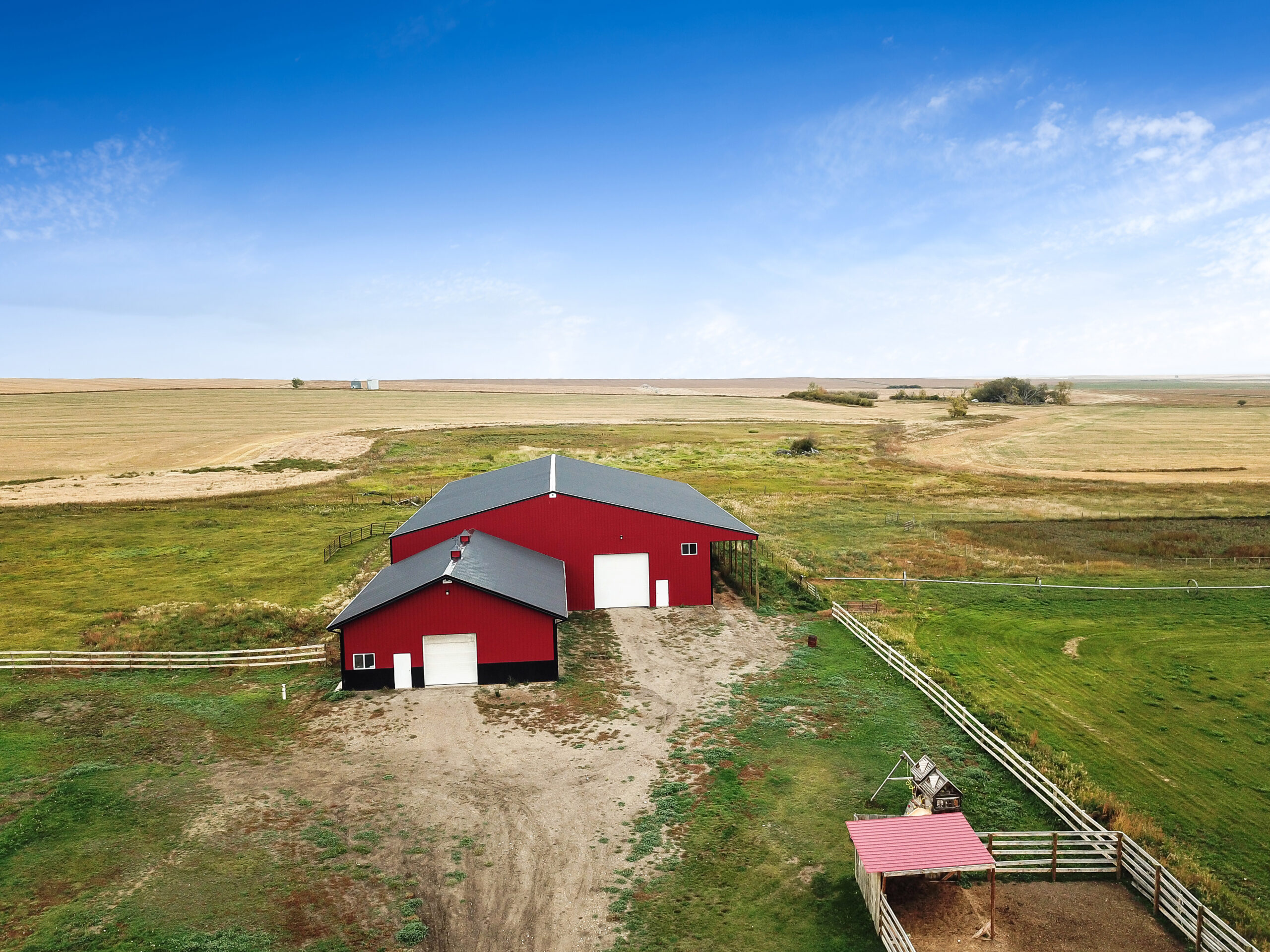 Drone image of an all-in-one equestrian facility featuring a horse barn and riding arena