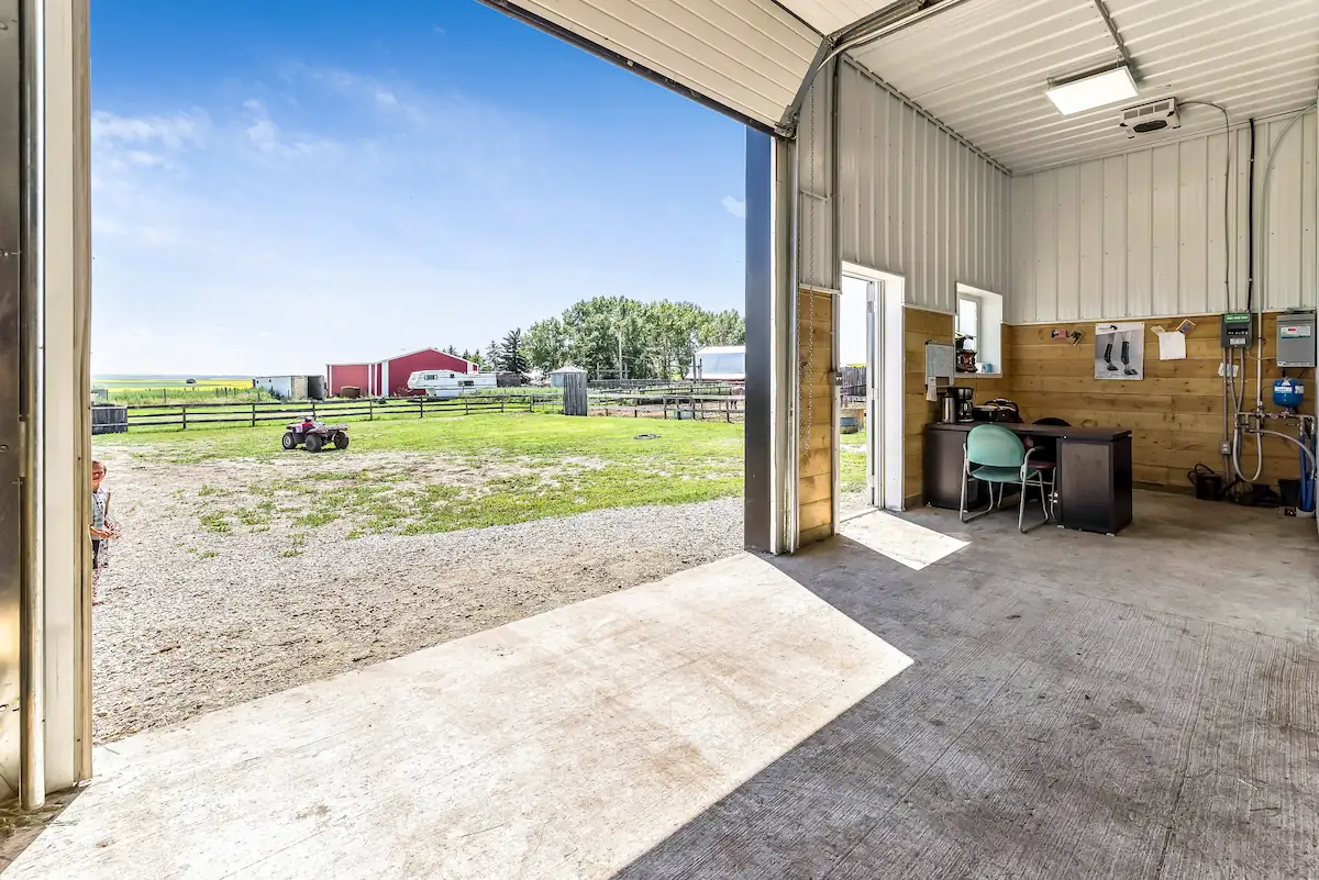 Inside of a pole barn for horses that includes a small office space to run an equestrian training business