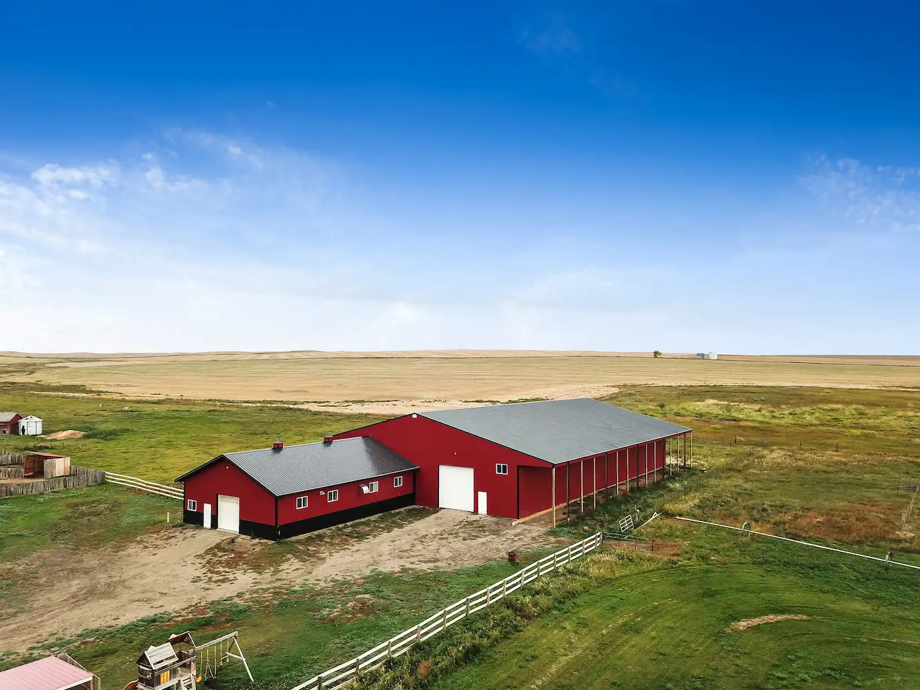 Equestrian facility with indoor riding arena attached to a horse barn for a rural Alberta business