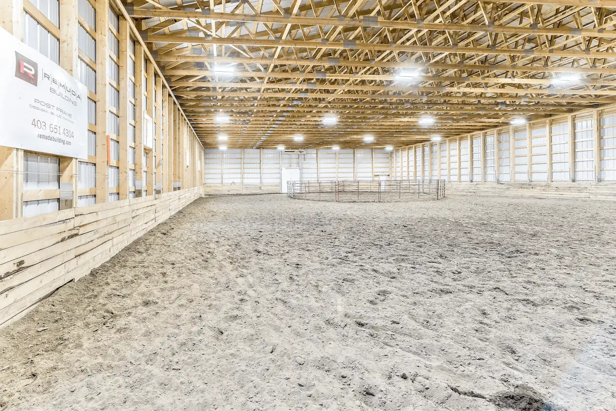 An unfinished riding arena interior with a 6' high kick wall.