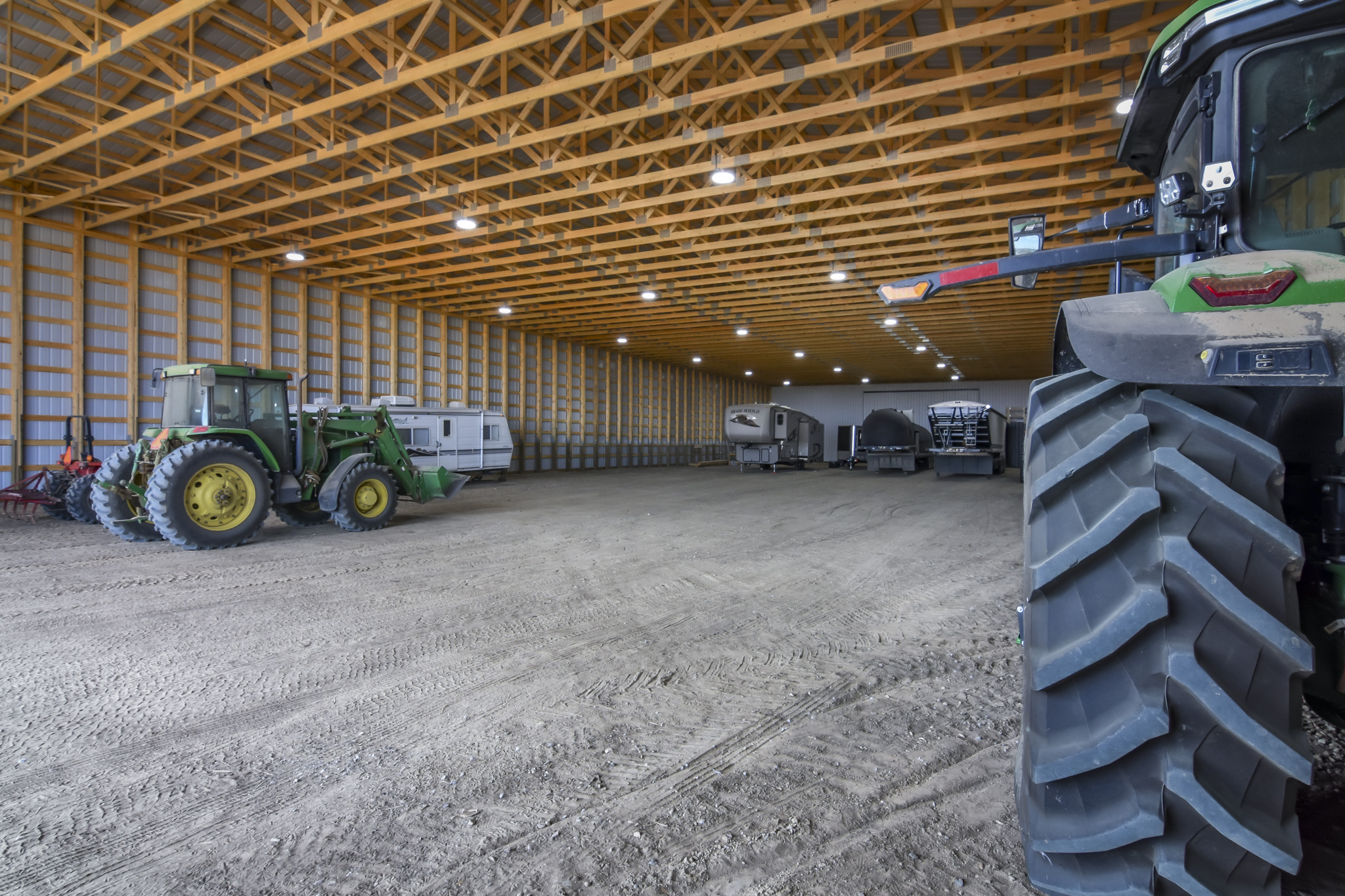 The interior of a post frame machine shed (pole shed) for farm equipment.
