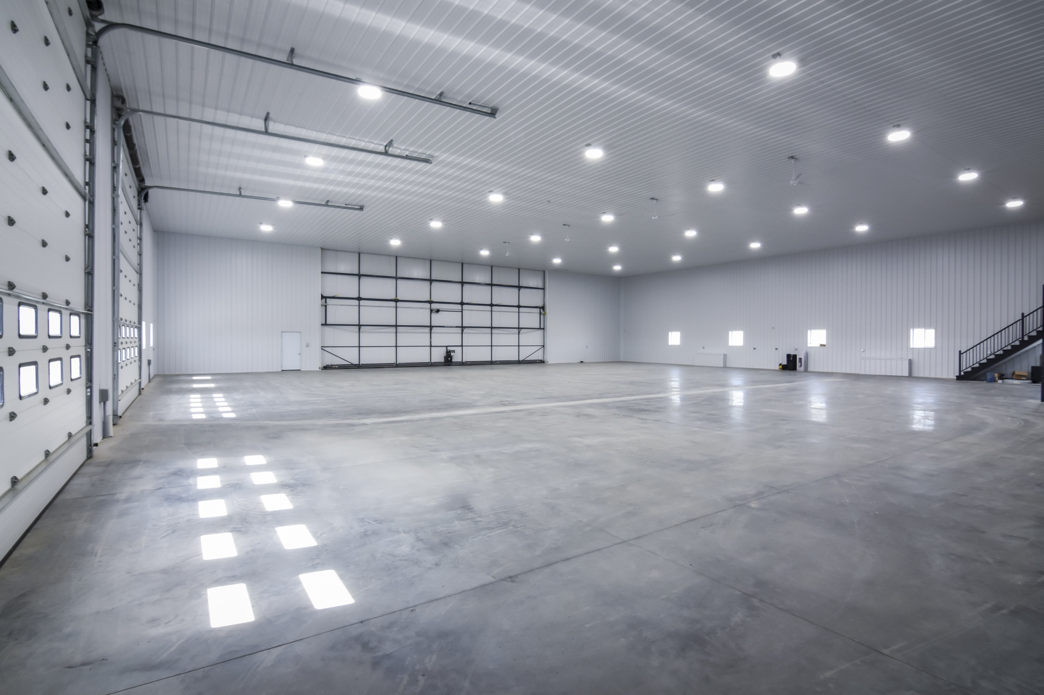 An insulated farm workshop with a concrete floor and metal walls.