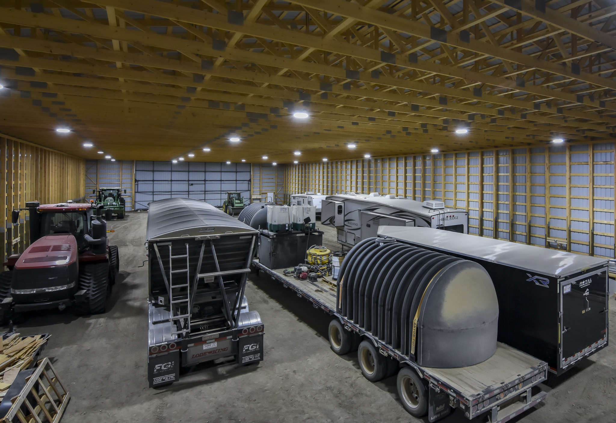 Filled with farm equipment, the machine shed shows a clear-span interior.