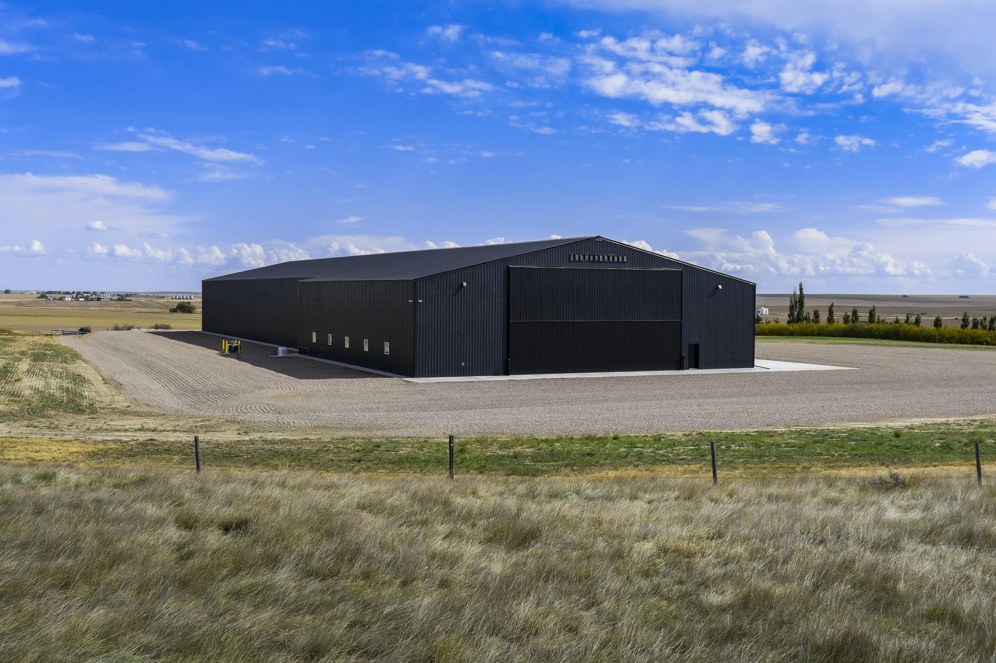 The exterior of a post frame facility that combines a farm workshop and machine shed.