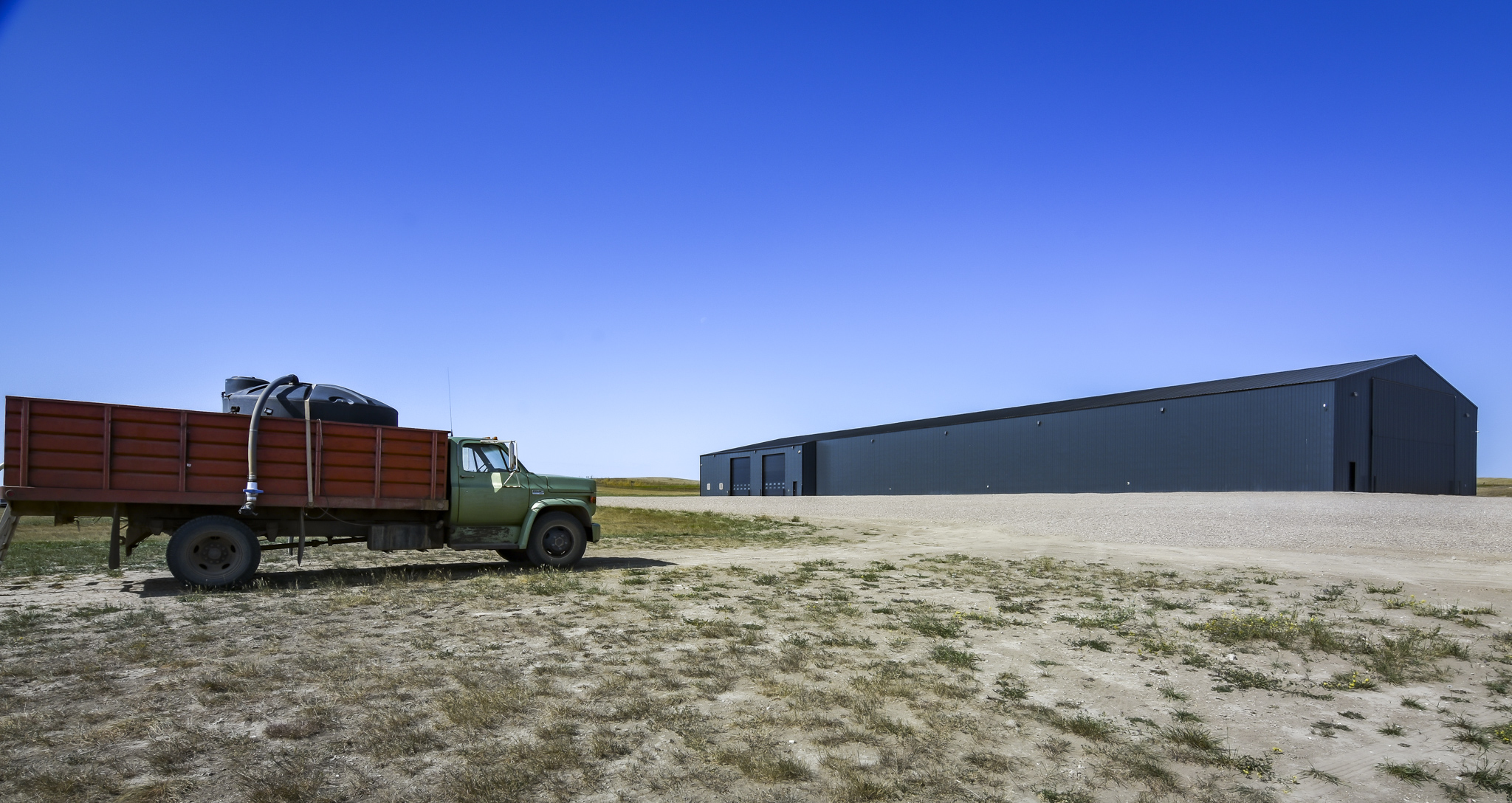 A photo of a large farm building shows the scale and size.