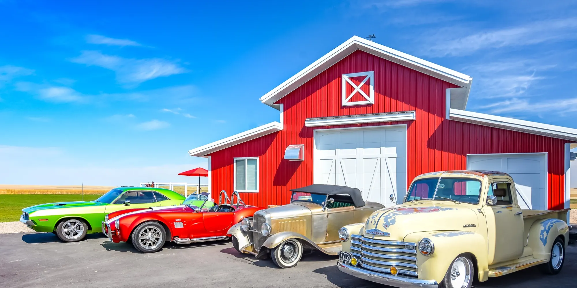 In a rural setting, a red monitor hobby shop sits showcasing a collection of classic cars.