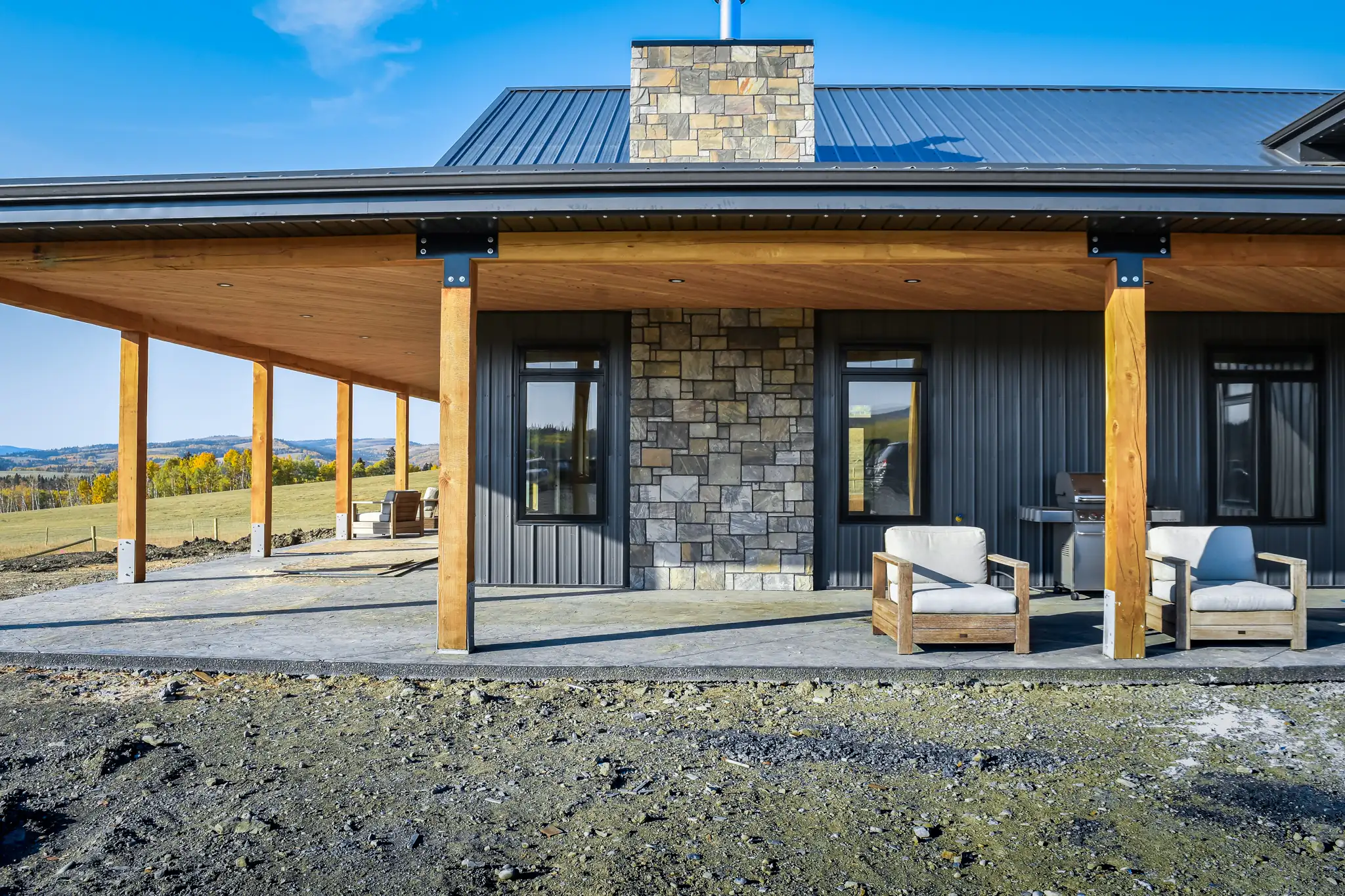 Barndominium exterior with rustic charm created by stone and timber detailing.