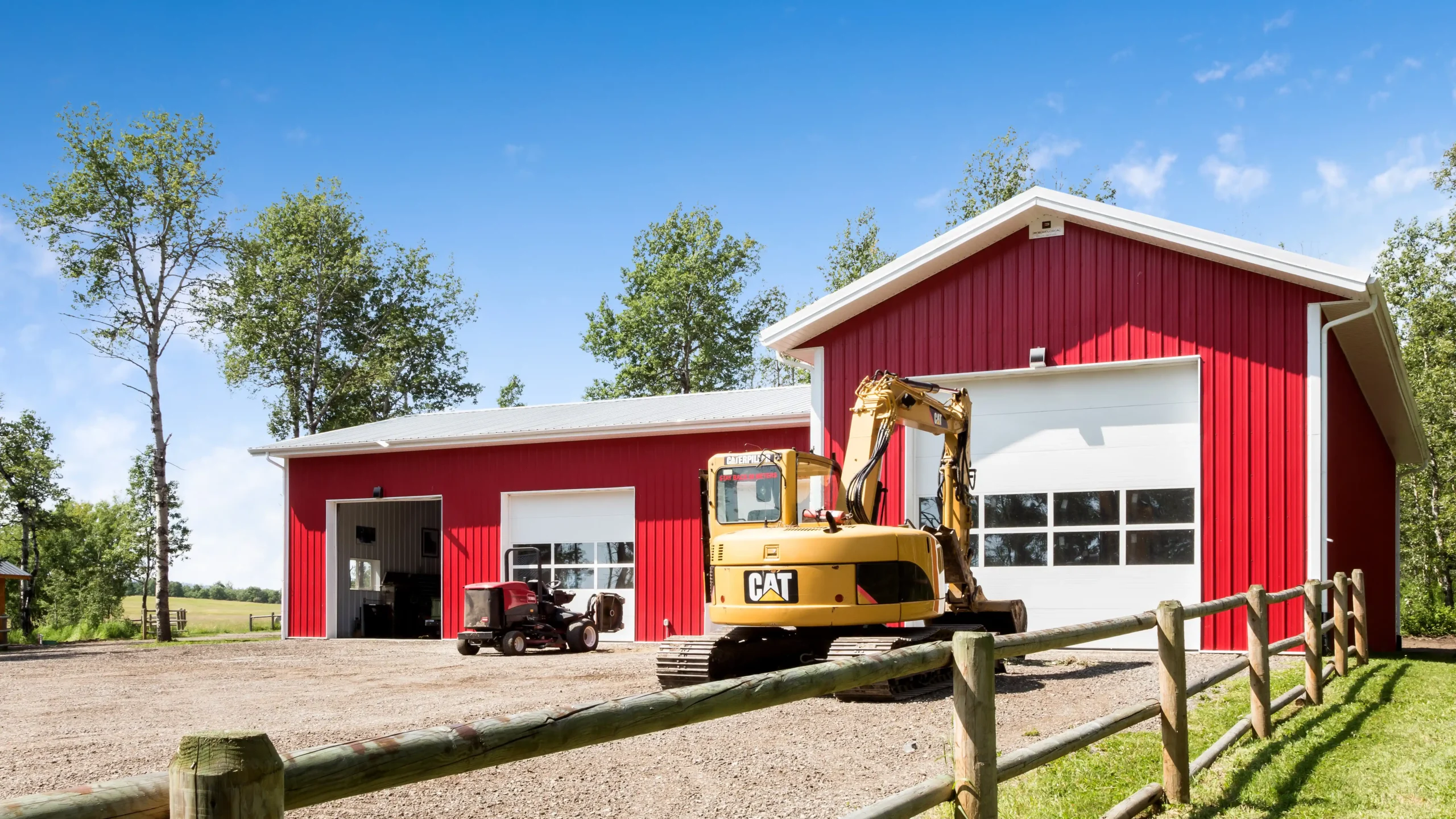 Red and white L shaped garage with 4 bay layout on a rural property.