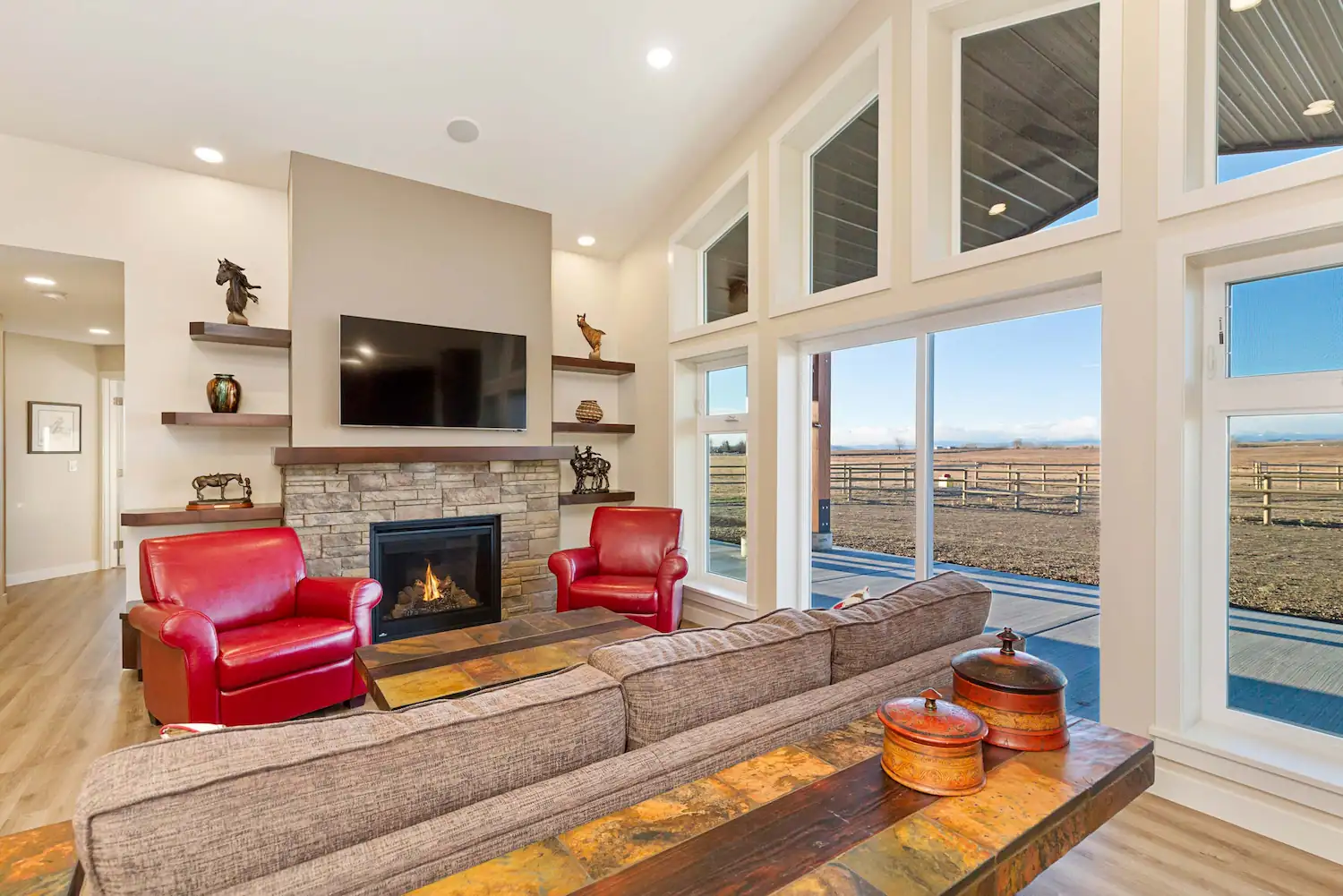 Large windows in a post frame barndominium offer mountain views in Alberta