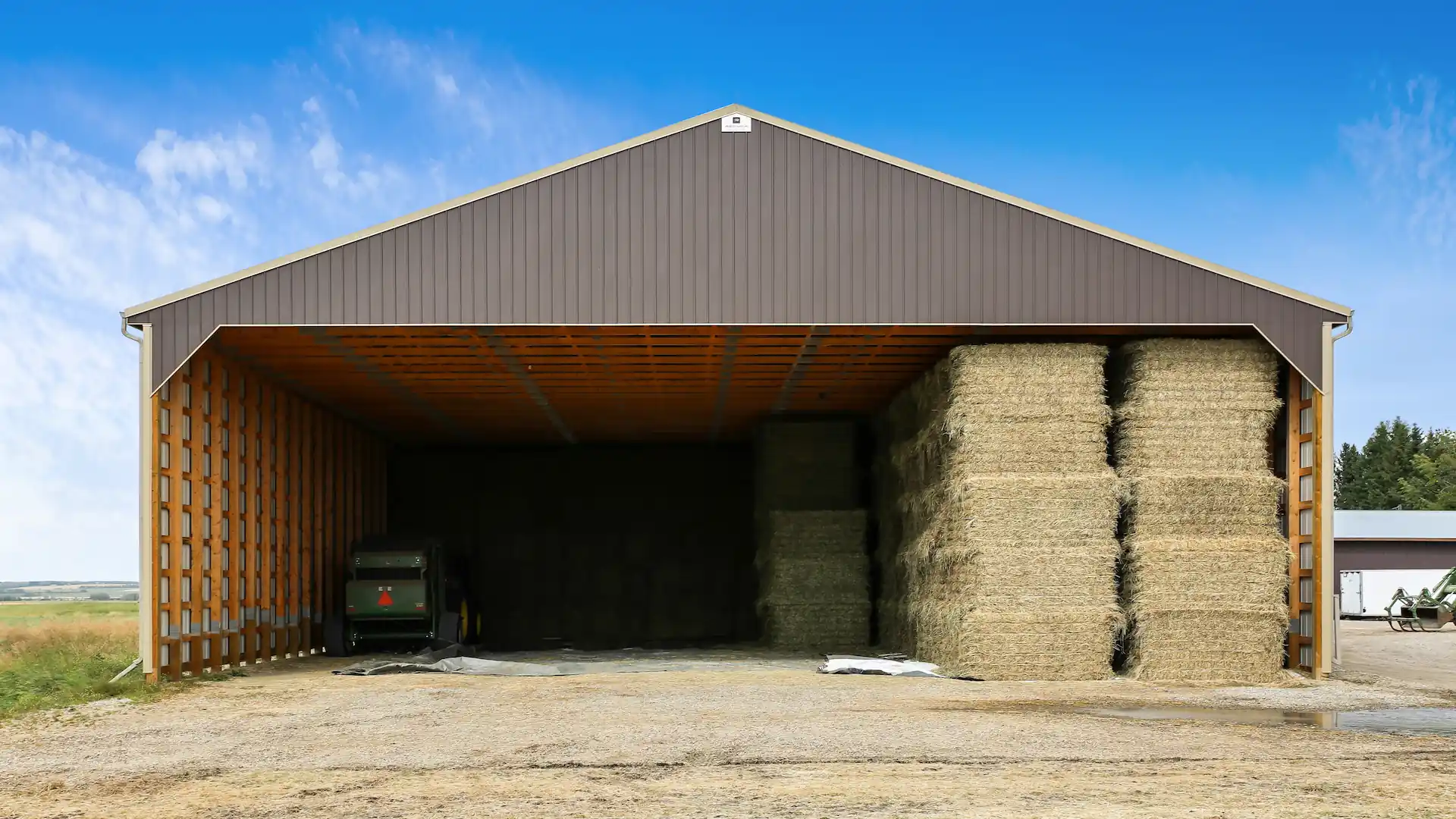 Open sided post frame farm building for hay storage
