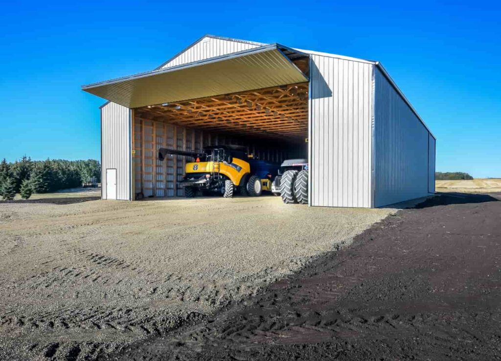 Large Pole Barn Farm Storage Building With Bi-fold Door An Equipment Inside
