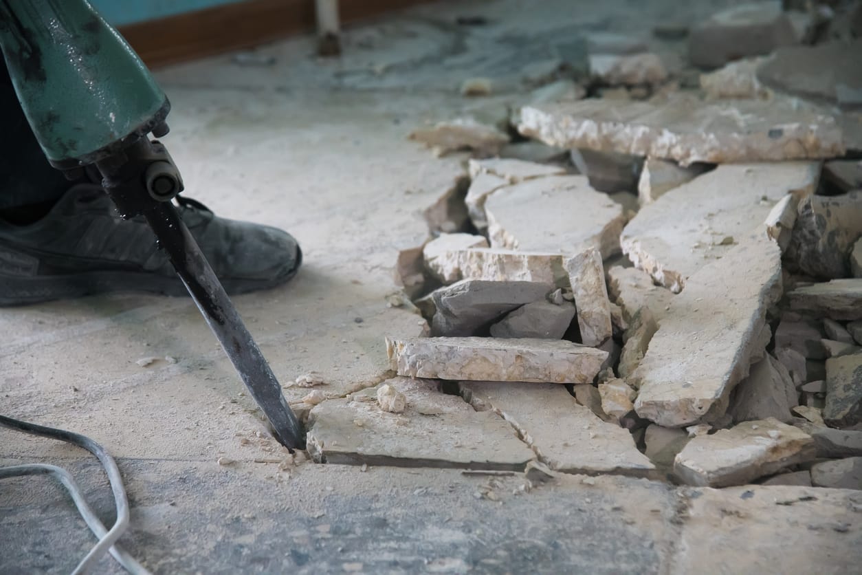 Concrete demolition of an old slab in progress with a jackhammer